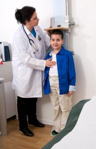 Pediatric nurse taking height of child